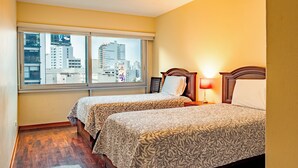 A hotel room with two beds, a large window, and a view of the cityscape. - Great location at Miraflores  (Lima)