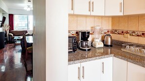 A kitchen with white cabinets, a coffee maker, a blender, and a kettle. - Great location at Miraflores  (Lima)
