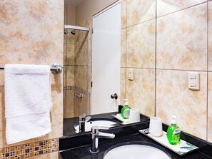 A bathroom with a sink, mirror, towel rack, shower, and toiletries. - Great location at Miraflores  (Lima)