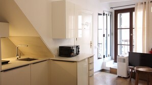 Una cocina compacta con microondas, lavaplatos y armarios.