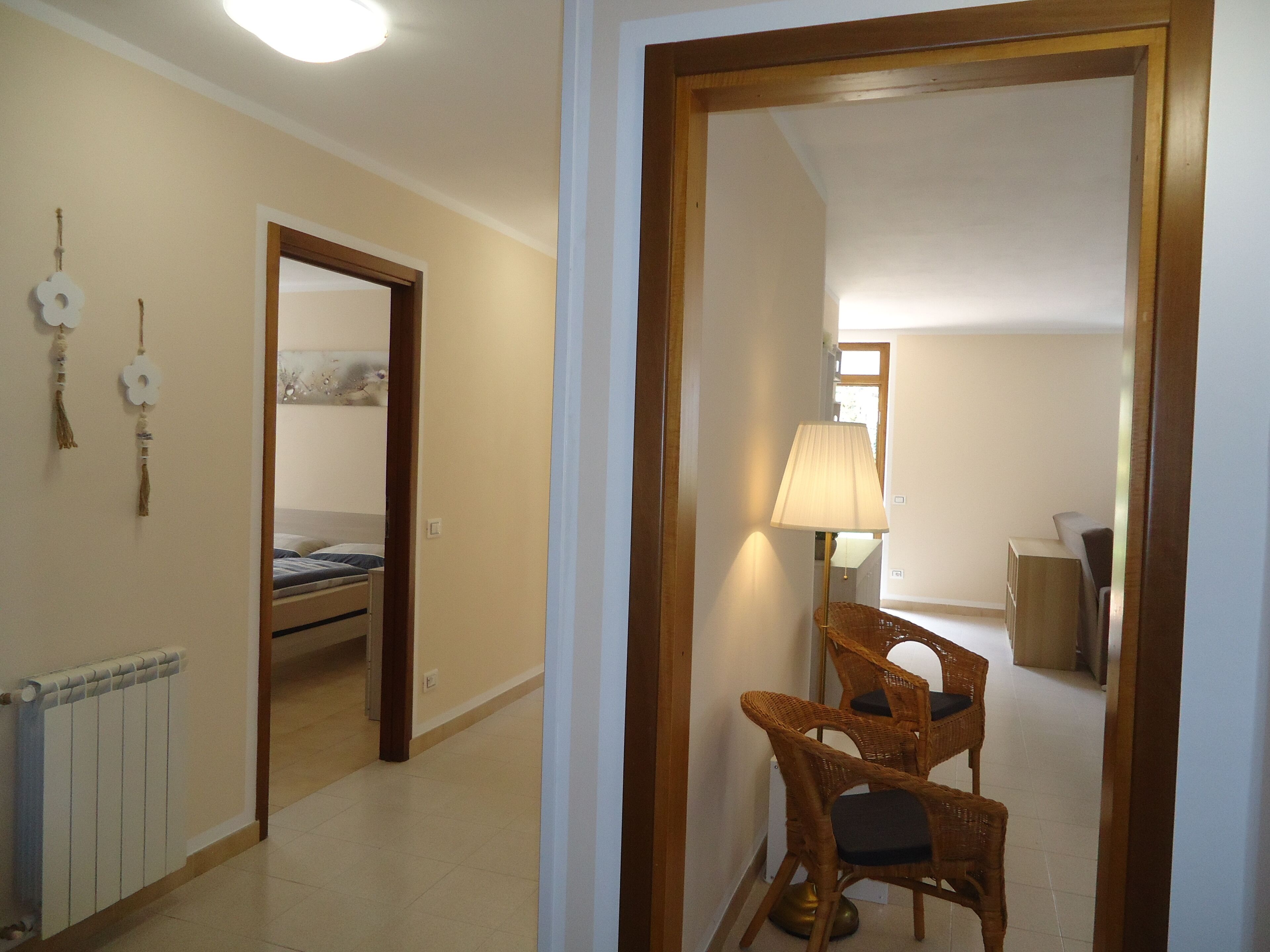A room with a bed, a chair, a lamp, and a radiator.