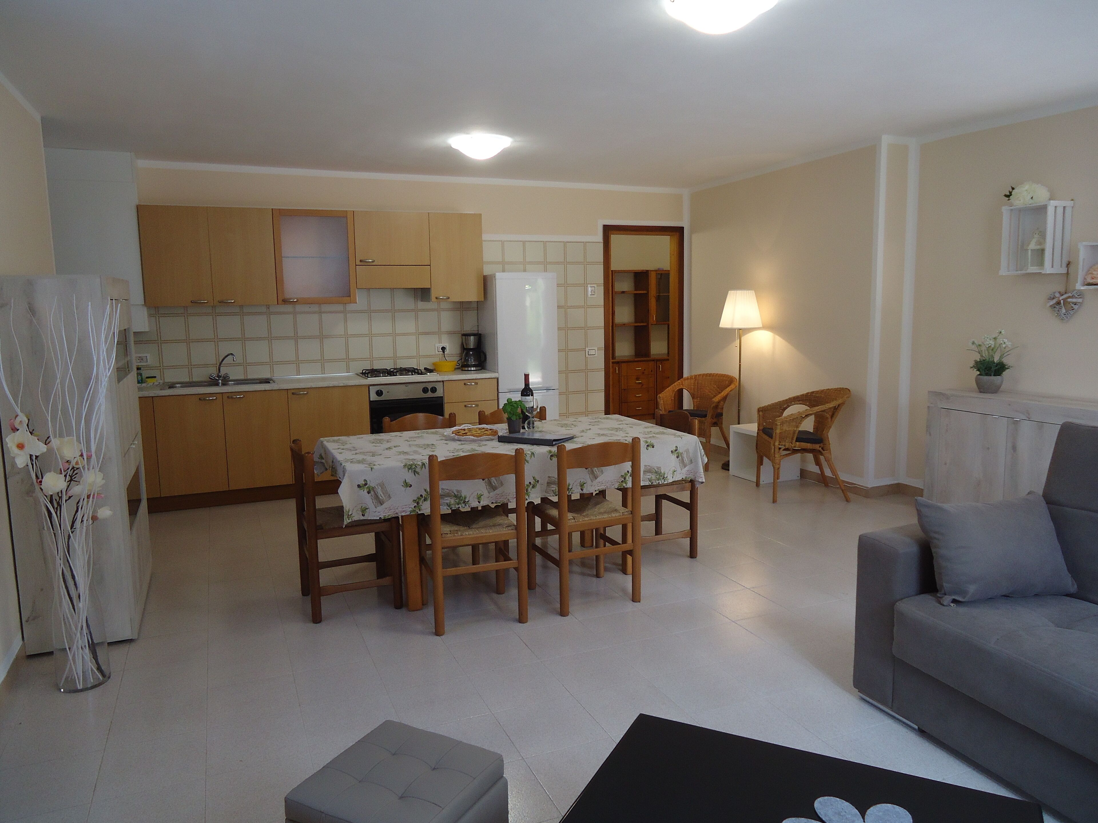 Un espace de vie compact comprenant un coin repas, une kitchenette et un canapé.