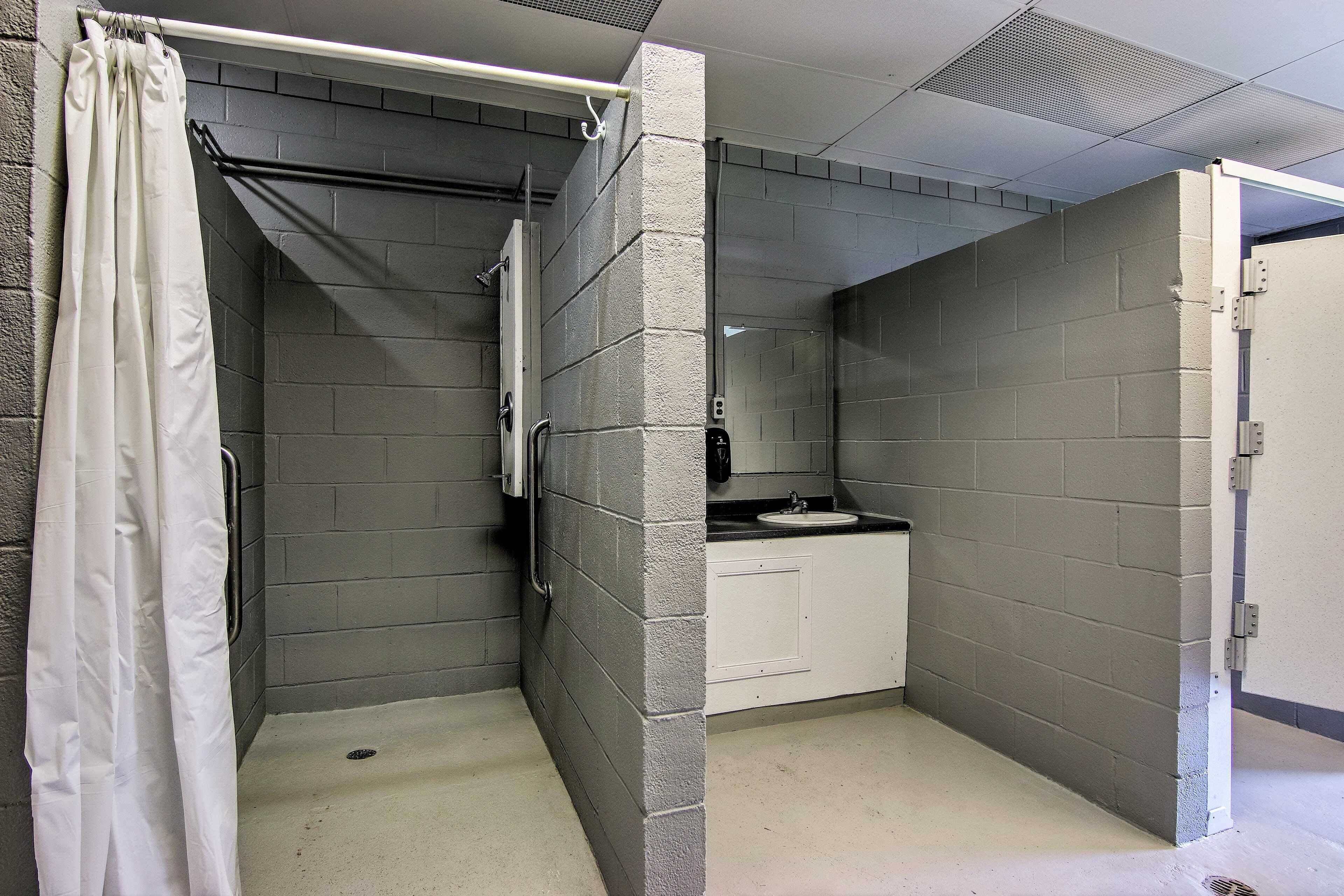 Ein kleines, abgeschlossenes Badezimmer mit Dusche, Waschbecken und Toilette.