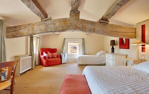 A bedroom with a sloped ceiling, a red sofa, a white bed, and a small window. - Fontblanche, Provencal estate for happy reunions (Gordes)