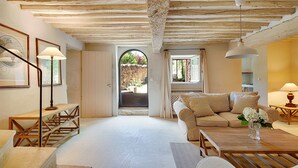 A spacious living room with a high ceiling, a sofa, a coffee table, and a staircase leading to an outdoor area. - Fontblanche, Provencal estate for happy reunions (Gordes)