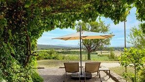 A patio with two chairs and a table under a pergola, overlooking a scenic countryside. - Fontblanche, Provencal estate for happy reunions (Gordes)