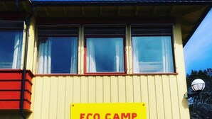 A building with a sign reading "ECO CAMP NORWAY" on a yellow background. - Eco Camp Norway - Hostel (Smøla)