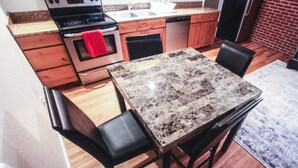 Una cocina con armarios de madera, encimera de granito, estufa de acero inoxidable y lavavajillas.