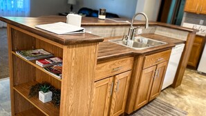 A kitchen with wooden cabinets, a sink, and a countertop.