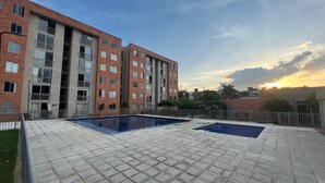A residential building with a rooftop pool area, featuring multiple swimming pools and a paved deck. - SUPERHOST APARTAMENTO, EXCELENTE UBICACION TULIPAN (Cúcuta)