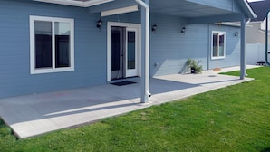 Een tweelaags huis met een overdekte veranda, een voordeur en een kleine voortuin.