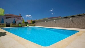 A swimming pool with a tiled deck, surrounded by a low stone wall and a building with a red roof. - Tapada da Beirã - Rural house (2-3 persons) (Marvão)