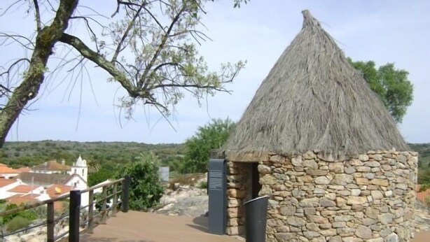 A thatched-roof hut with a stone wall, a wooden bench, and a metal railing. - Tapada da Beirã - Rural house (2-3 persons) (Marvão)