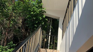 A staircase with a modern design, leading to a building with a white exterior and stone-textured steps. - Jazmin Apartments Vacations (Samaná)