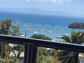 A coastal view with a bridge, boats, and lush greenery. - Jazmin Apartments Vacations (Samaná)