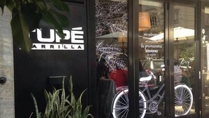A storefront with a sign reading "UNDE ARRILLA" and decorative bicycle graphics on the window. - Beautiful apartment with french balcony. (Buenos Aires)