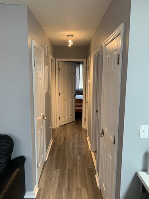 Stylish hallway leading to a cozy room with a bed and window.