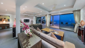 A modern living room with a sofa, coffee table, and a view of the ocean. - Ban Nai Fan: 3 Bed Pool Villa w/ Magnificent Sea View (Ko Samui)