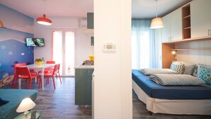 Ein modernes Zimmer mit Essbereich, Küchenzeile und einem Bett.