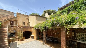 A courtyard with a stone staircase, a brick archway, and a table with chairs. - Holiday rental townhouse in Begur, Centre (Begur)