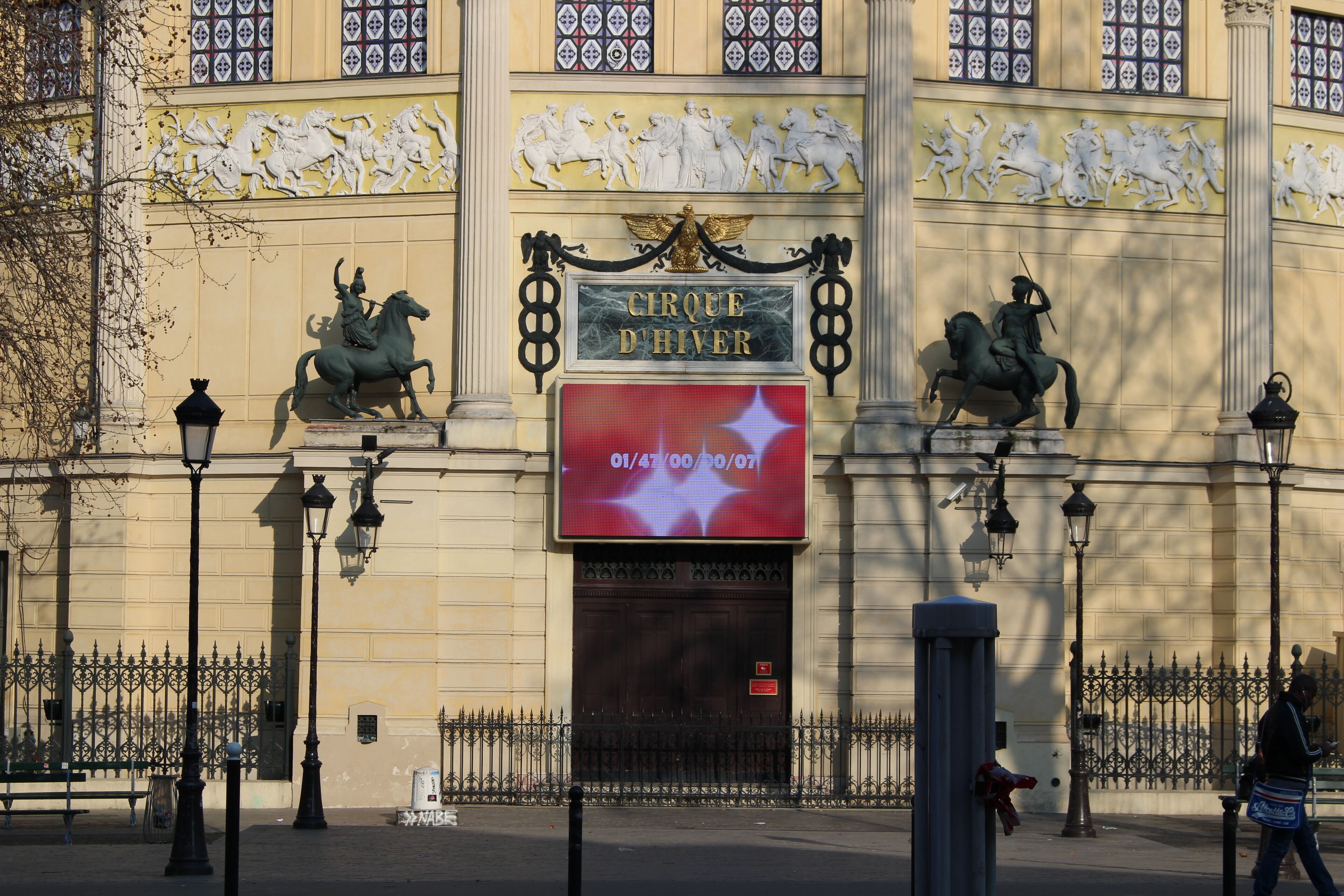 A building facade with classical architecture, including statues and decorative elements.