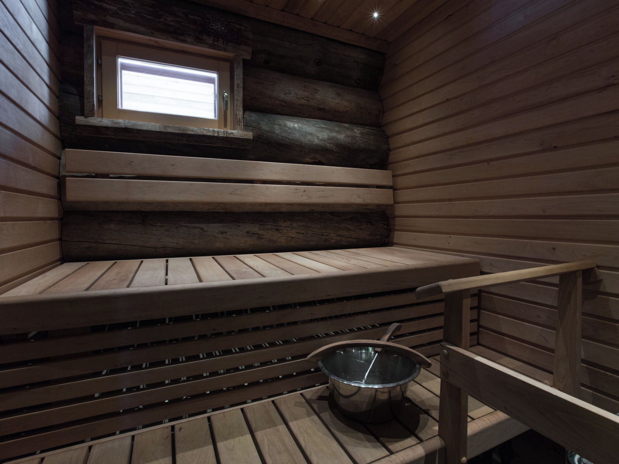 Eine Sauna mit Holzbänken und einem kleinen Fenster.