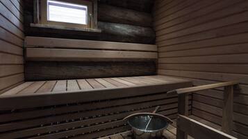 Eine Sauna mit Holzbänken und einem kleinen Fenster.