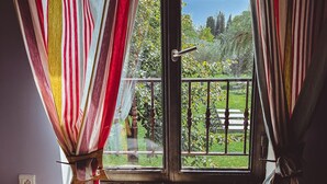 Une pièce donnant sur un balcon grâce à une porte vitrée, le balcon étant doté d’une rambarde en métal.