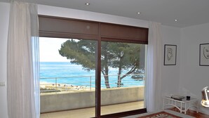 A bedroom with a large sliding glass door leading to a balcony with a view of the sea and trees. - Villa in Begur with sea views-Capacity 9 people.-A/C.Pool. BEGUR-COSTA BRAVA (BEGUR)