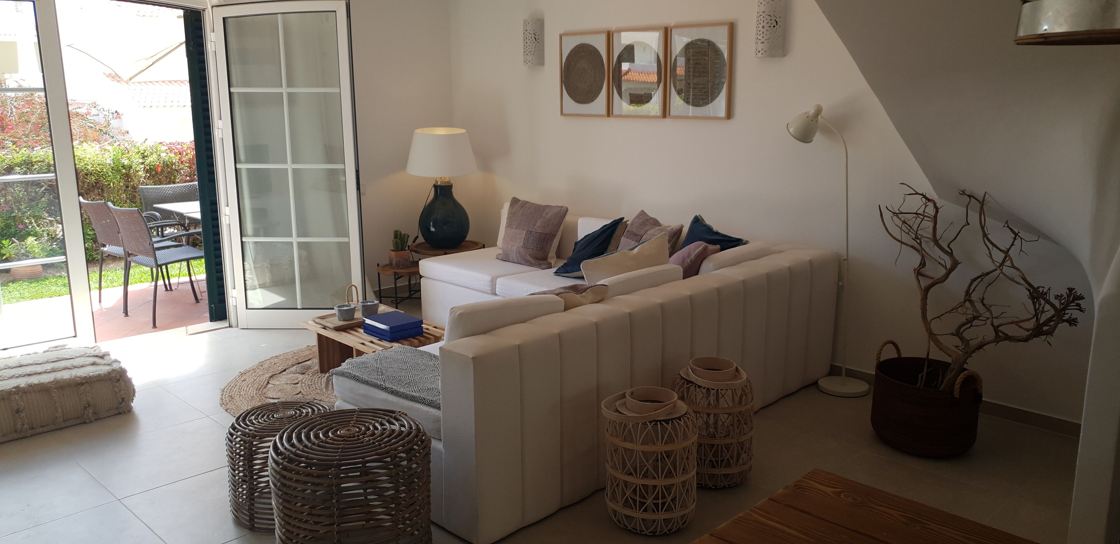 A modern living room with a sofa, a coffee table, a lamp, and a potted plant.