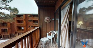 Enjoy the view from this balcony with a railing and a chair, overlooking the surrounding buildings.