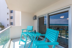 Relax on the ocean-facing balcony with a view of the sea, featuring a table and chairs for a peaceful retreat.