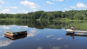 A calm lake with a dock and a small boat.