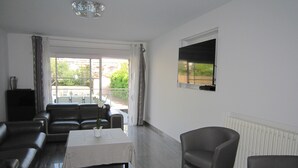 Un soggiorno moderno con un divano, un tavolino da caffè e una TV a parete.