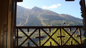 A wooden balcony with a view of a mountainous landscape. - Chalet / stone house (Sainte-Foy-Tarentaise)
