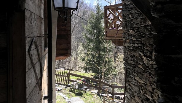 A rustic wooden building with a stone wall and a lantern hanging from the ceiling. - Chalet / stone house (Sainte-Foy-Tarentaise)