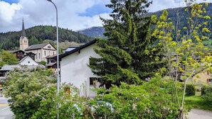 A rural village with traditional houses, a church, and a large tree in the foreground. - ABC Ferienwohnung 1 1. OG Süd by Interhome (Fiesch)