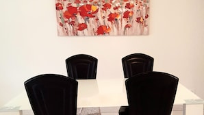 A dining area with a white table and four black chairs.