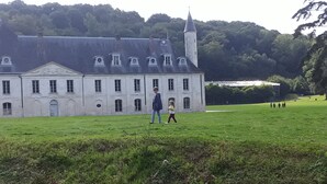 Un grand bâtiment historique doté d’une tour imposante et de fenêtres disposées de manière symétrique.