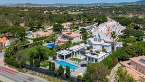 A residential area with modern houses, a swimming pool, and a road with a pedestrian path. - Villa Allegra - Quinta do Lago (Quinta do Lago)