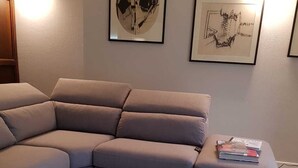A modern living room with a L-shaped sofa, a glass coffee table, and two framed artworks on the wall. - Chocolat la Mairie in Omegna (Omegna)
