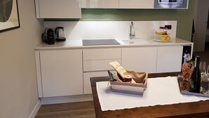 A modern kitchen with white cabinets, a built-in microwave, and a coffee maker. - Chocolat la Mairie in Omegna (Omegna)
