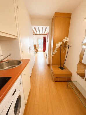 A narrow hallway leading to a dining area with a view of a balcony. - Le Loft Boissy (Paris)
