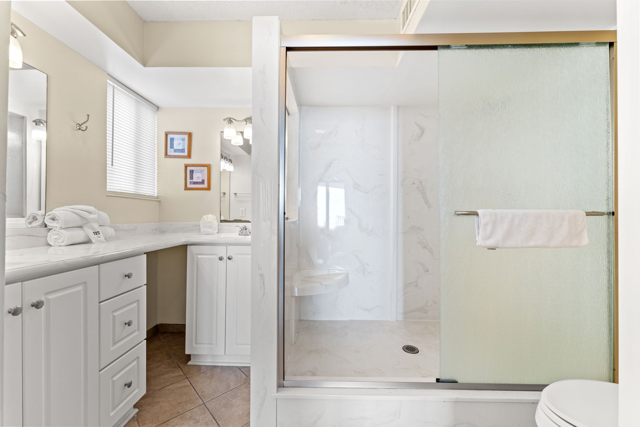 Een badkamer met douche, toilet en wastafel.