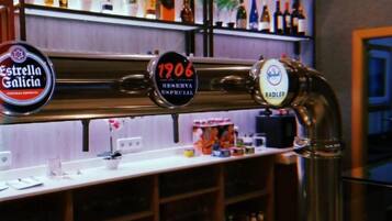 Un bar con una grifo etiquetado '1906 Reserva Especial' y cerveza Estrella Galicia.