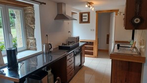 Una cocina moderna con una isla central, horno empotrado y una pared decorativa de piedra.