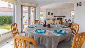 A dining area with a round table set for six, surrounded by wooden chairs. - Arribas Villa by Interhome (Guia)