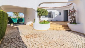 A modern white building with a courtyard, stone paving, and potted plants. - Arribas Villa by Interhome (Guia)