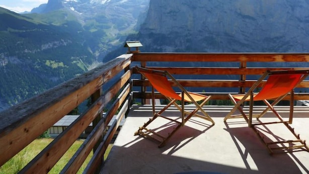 A wooden deck with two folding chairs overlooking a mountainous landscape. - Apartment Gloria by Interhome (Mürren)