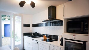 A modern kitchen with white cabinets, a black microwave, and a Bosch oven.